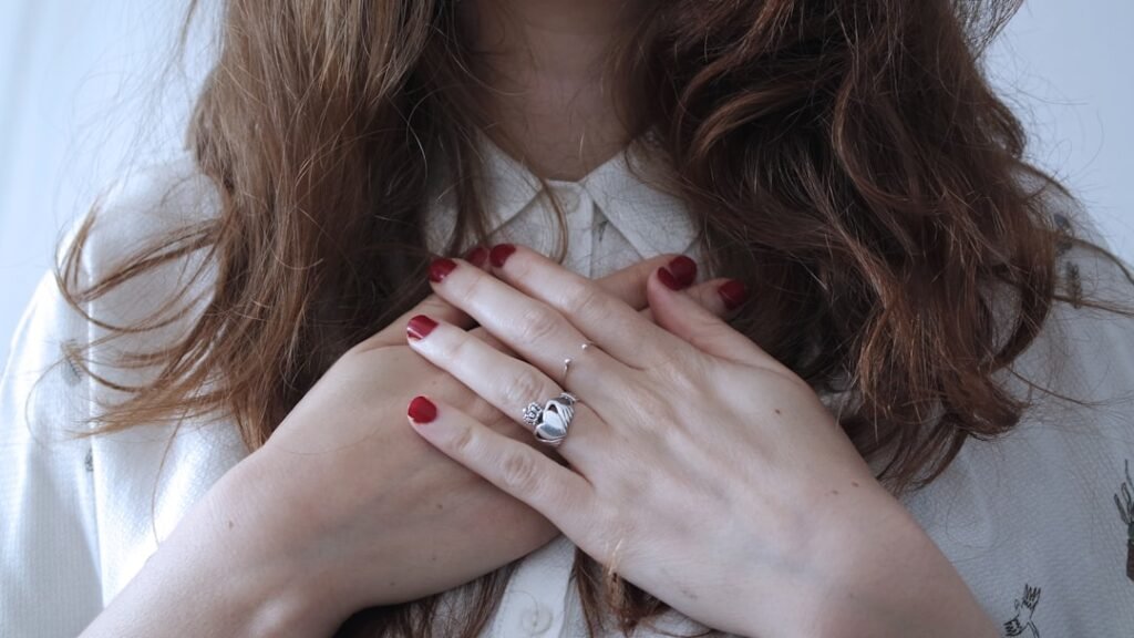 Person resting hand on chest in a moment of calm