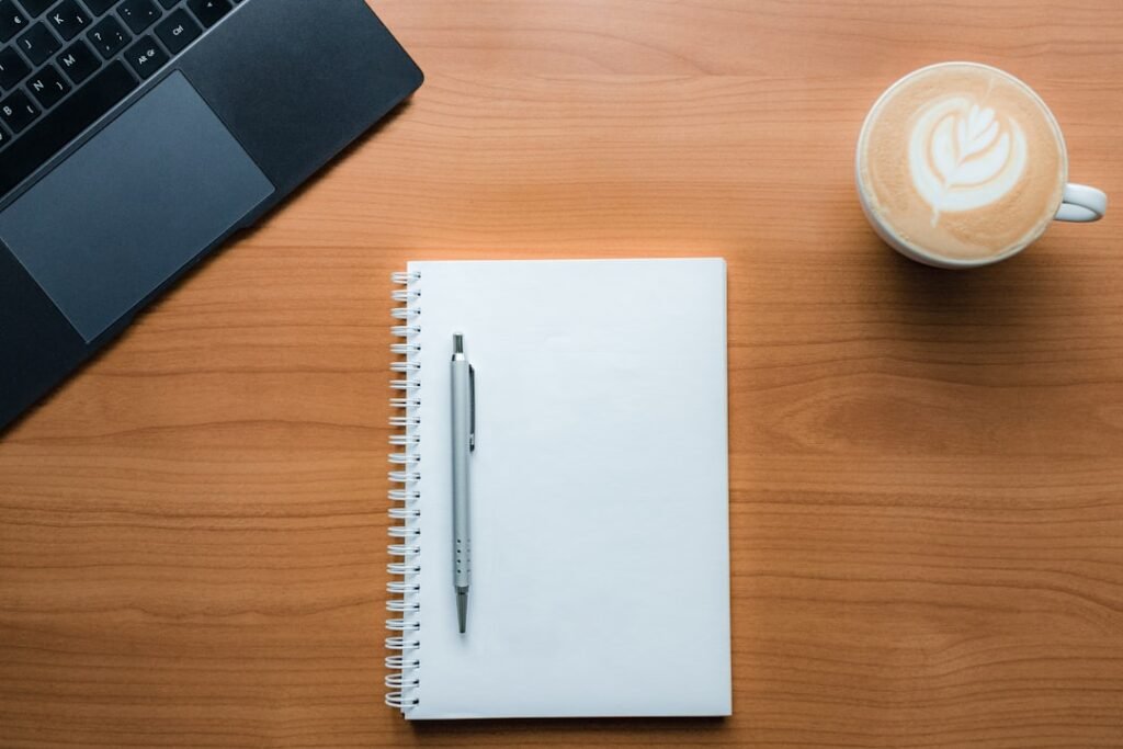 Open journal with pen and morning coffee on a desk