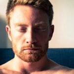 Person meditating with eyes closed in calm natural light
