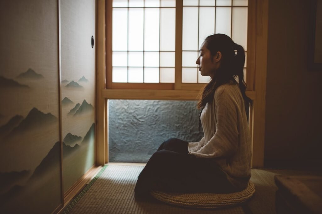 Quiet meditation on a cushion by a sunrise window