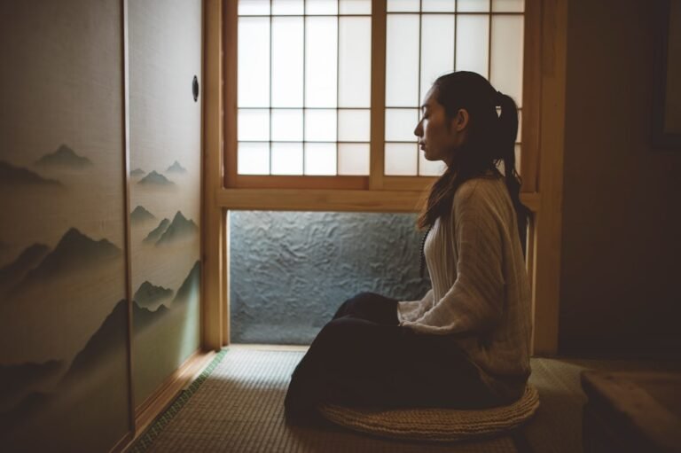 Quiet meditation on a cushion by a sunrise window