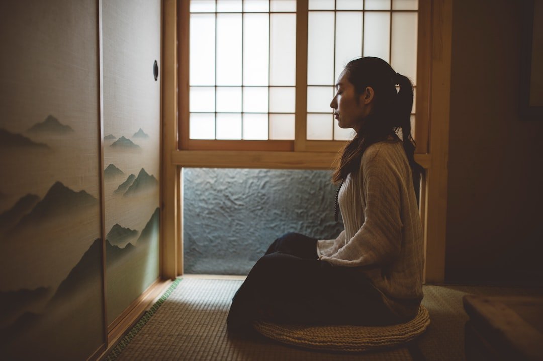 Quiet meditation on a cushion by a sunrise window