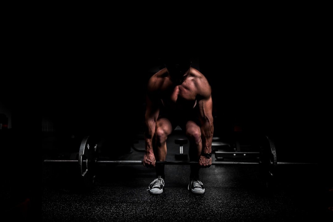 Weightlifter doing a mobility stretch by a barbell
