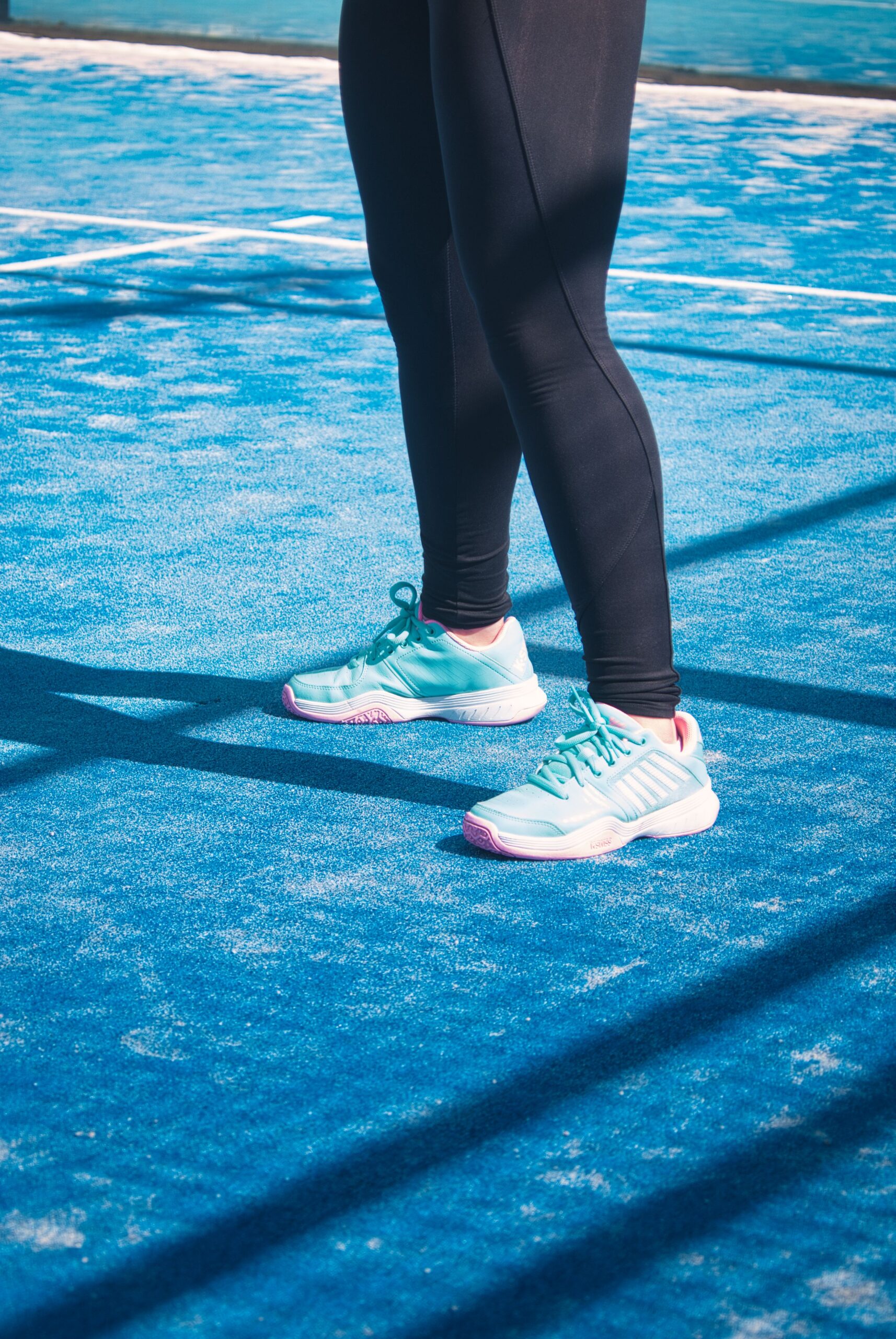 Pastel court shoes and leggings on a blue sports court